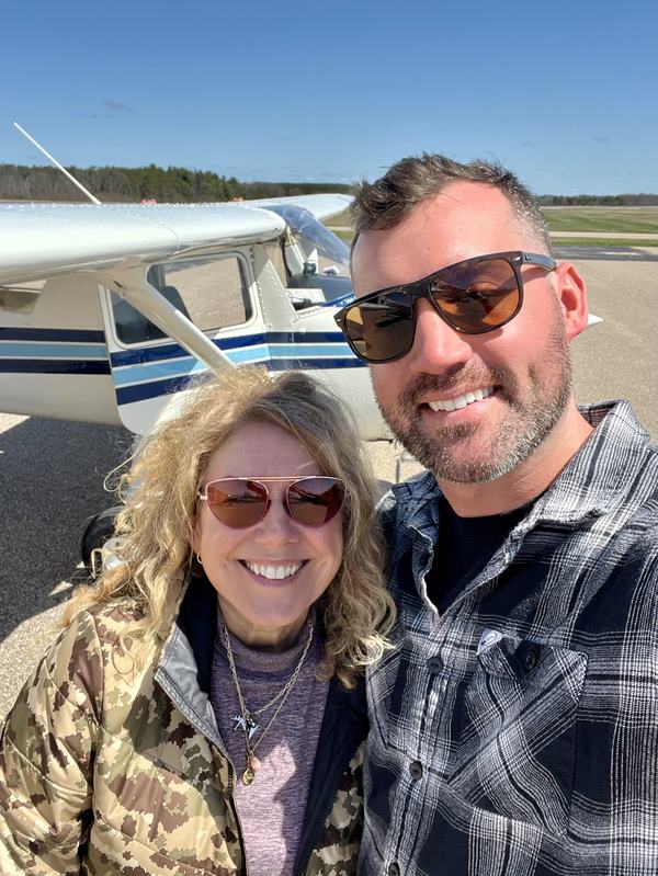 Mary Shandonay with her flight instructor, Austin, with her Cessna airplane in the background.